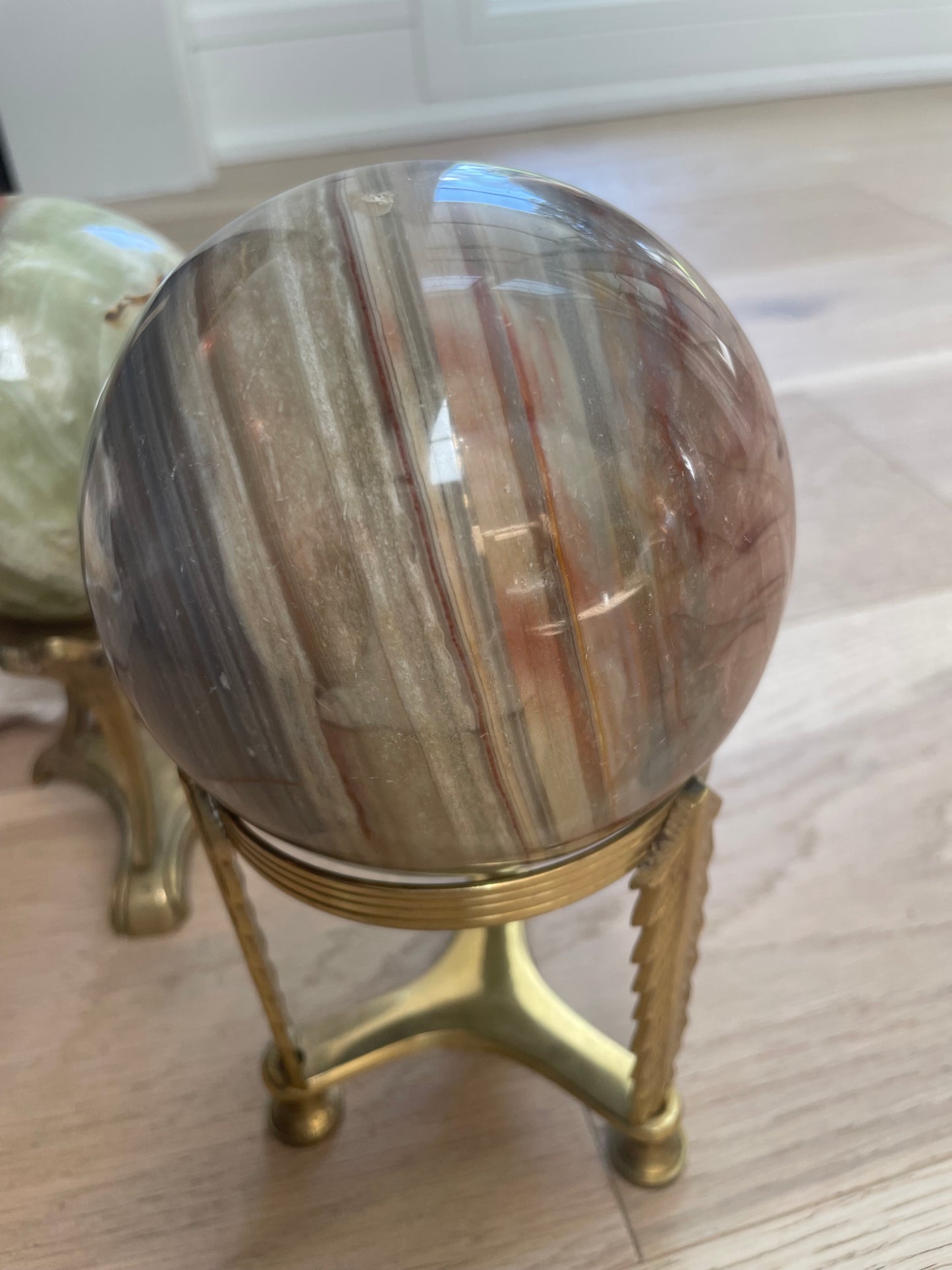 Large ocean jasper sphere with brass stand